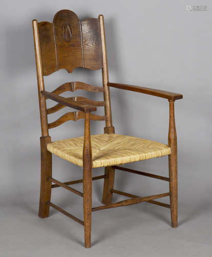 An Edwardian Arts and Crafts oak and ash framed elbow chair,...