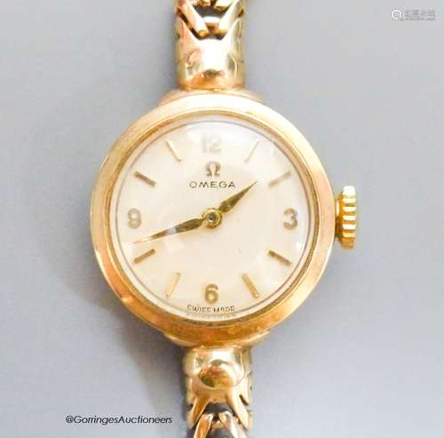 A lady's 9ct gold Omega manual wind wrist watch, on a 9ct go...