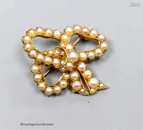 A yellow metal and split pearl set ribbon bow brooch, 30mm, ...