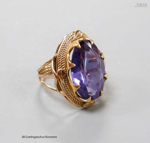 A yellow metal and synthetic colour change sapphire set oval...