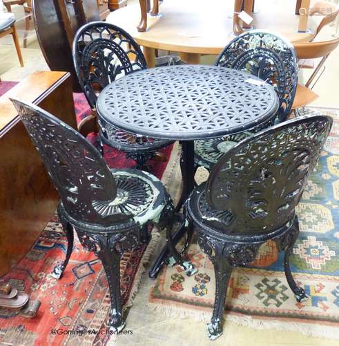 A tilt-top cast metal garden table and four chairs. Table, D...