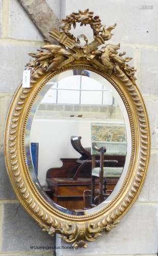 A late Victorian, gilt wood and gesso oval wall mirror, with...