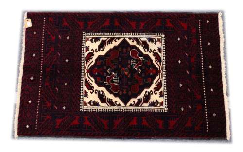 A PERSIAN RUG, 20th Century red ground with a central cream ...