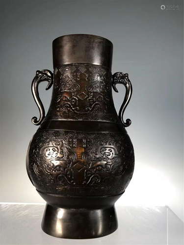 A CARVED BRONZE VASE WITH DOUBLE HANDLES