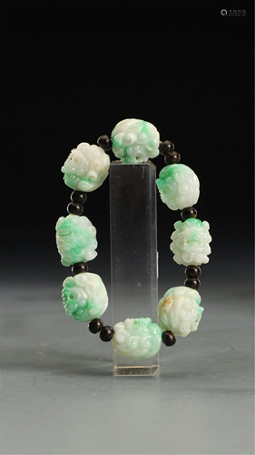 A STRING OF CARVED LION HEADS JADEITE BRACELET