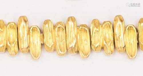 Bracelet souple en or jaune, composé de bâtonnets guillochés...
