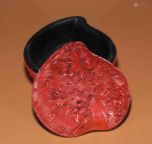 A CARVED CINNABAR LACQUER NEZHA STORY PEACH-SHAPED BOX AND C...