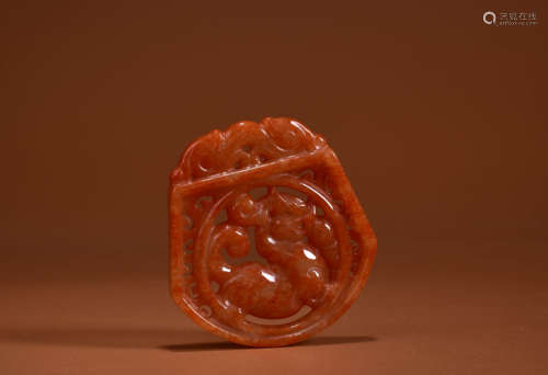 A MOTTLED RED JADEITE DRAGON PENDANT