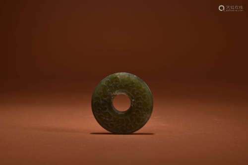 A GREENISH JADE ANNULAR PENDANT BI