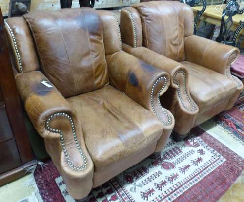 A pair of tan leather armchairs, W.94cm D.94cm H.90cm (one a...