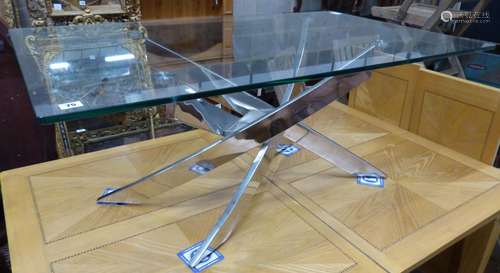 A modern plate glass topped coffee table, with a stainless s...