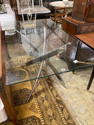 A modern plate glass topped dining table, with a stainless s...