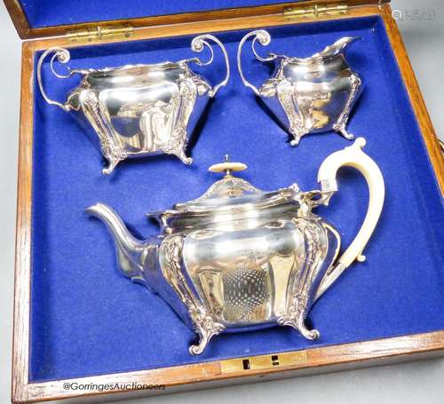 An oak cased Edwardian silver three piece tea set, James Dix...