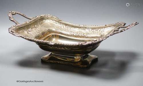 A late George III silver two handled bread dish, embossed wi...