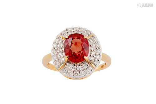 An orange sapphire and diamond cluster ring