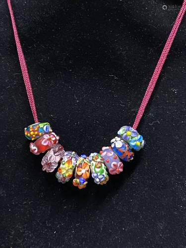 A STRING OF POLYCHROME GLASS BEADS