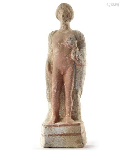 A TERRACOTTA FIGURE OF A STANDING MAN HOLDING A BIRD, HELLIN...