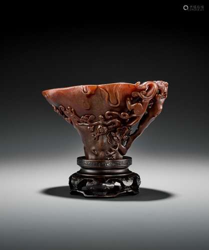 A RHINOCEROS HORN 'CHILONG AND PRUNUS' LIBATION CUP, EARLY T...