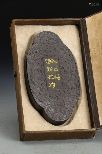 A CARVED DRAGONS INK BLOCK WITH GOLDEN CHARACTERS