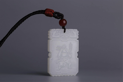 A CARVED ARHAT NANDIMITRA JADE PENDANT