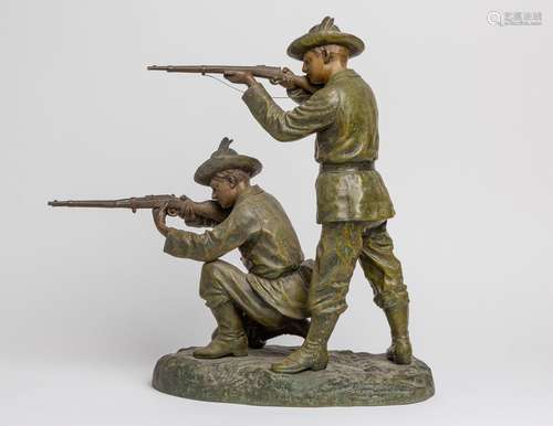 A painted spelter figure group of two huntsmen firing their ...