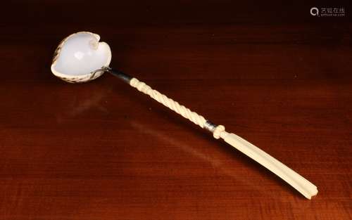 A Cowrie Shell Ladel mounted on a bone handle with a wrythen...