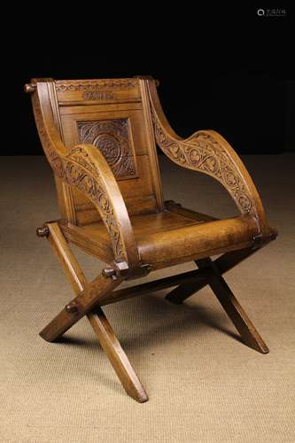 A 19th Century Carved Oak X-frame Chair in the manner of the...