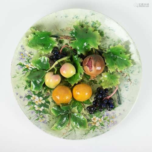 Large antique dish in barbotine with fruit and grape leaves