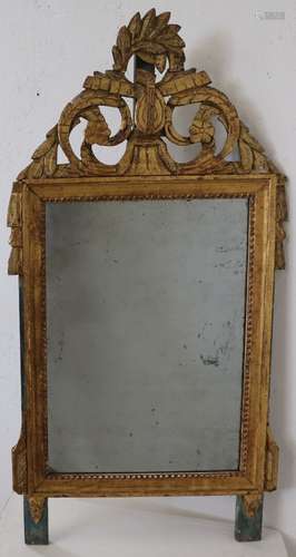 Miroir en bois laqué vert et doré à décor au fronton d'une m...