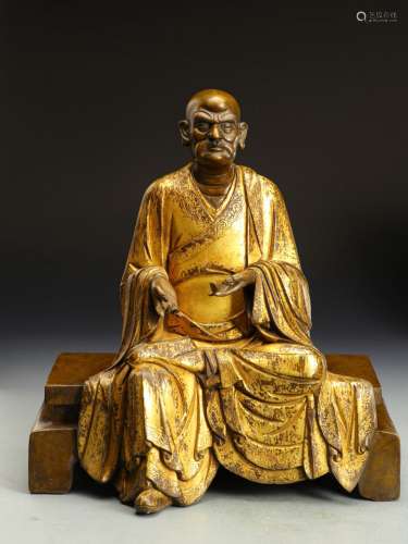 A MING DYNASTY BRONZE GILDED ARHAT STATUE