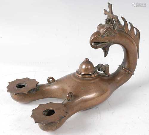 * A suspending bronze oil lamp, cast with a griffins head su...