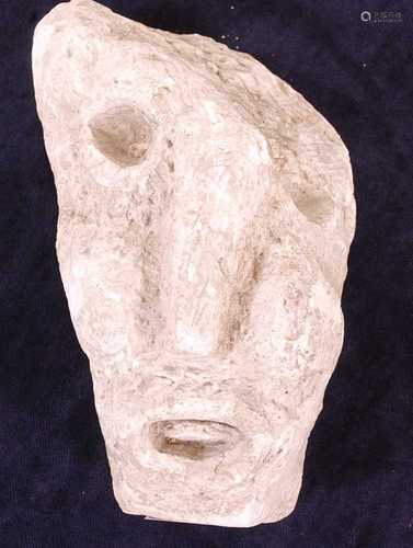 * A limestone fragment carved as a male head, early Medieval...