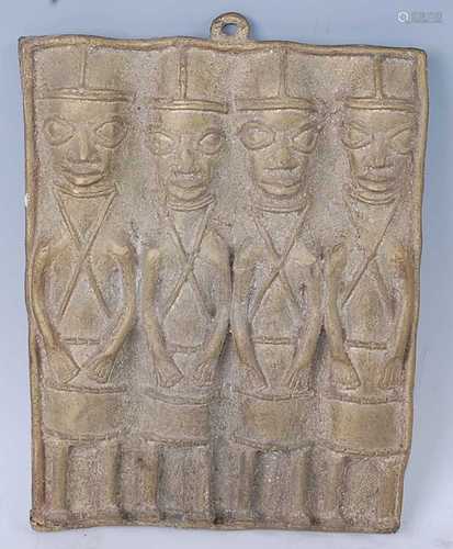 A cast brass plaque depicting four figures each in standing ...