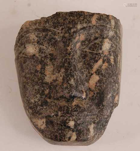 * A granite fragment, carved as a face, Egyptian New Kingdom...