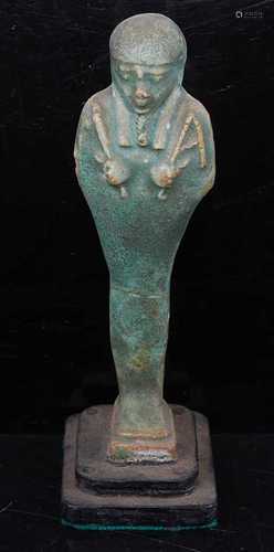 An Egyptian green glazed faience shabti, the standing figure...