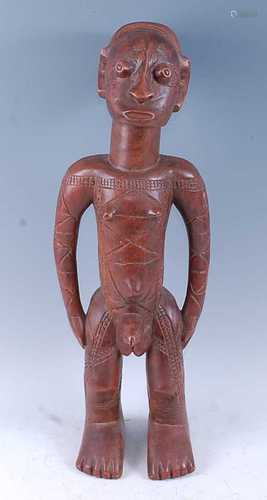 A large wooden figure, carved as a male in standing pose wit...