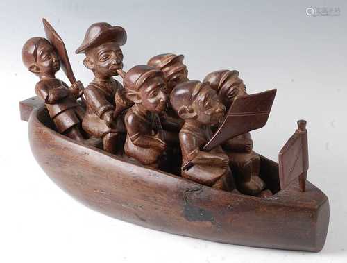 * A large carved hardwood model of a boat with six individua...