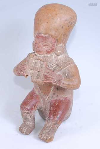 A pottery figure, modelled as a male musician in seated pose...