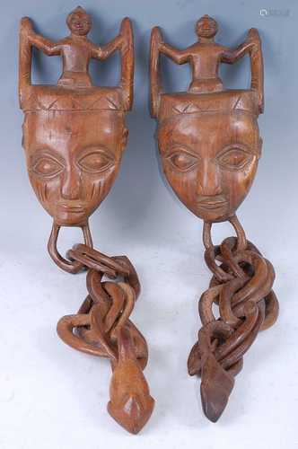 A pair of marriage ritual masks, each carved as a human face...