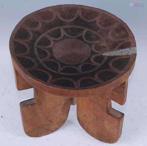 An African hardwood stool, the dished seat with concentric c...