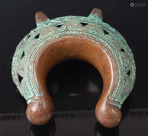 * A cast copper currency bracelet, having pierced and incise...