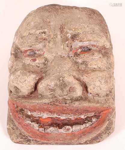 * A limestone head, carved as a male face with polychrome de...