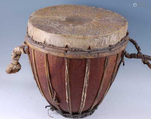 A large African drum, the hide stretched over a wooden base ...