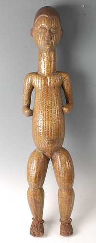 * A large carved wooden power figure in the form of a standi...