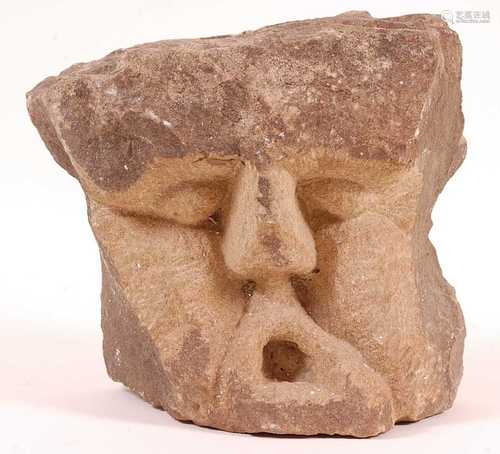 * An architectural sandstone block, carved as a male face wi...