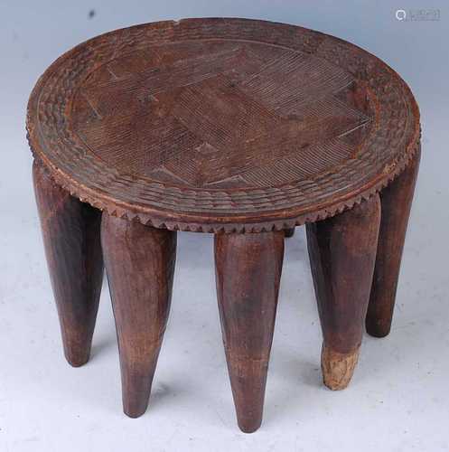 An African hardwood stool, the circular slightly dished seat...