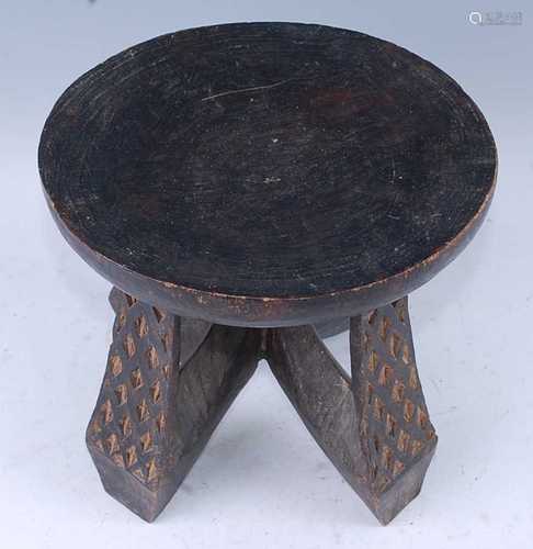 A West African hardwood stool, the circular dished seat rais...