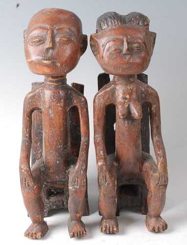 * A pair of King and Queen figures, each in seated pose with...