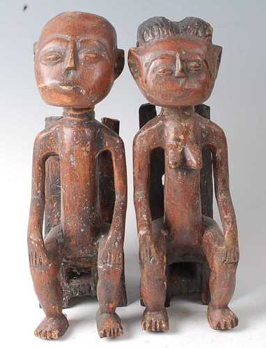 * A pair of King and Queen figures, each in seated pose with...