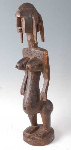 * A large ancestor figure, carved as a female in standing po...